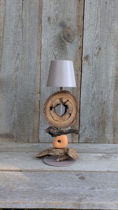 Warme LED-Tischleuchte mit liebevoll arrangiertem Holz im Chaletstil. Natürliche Strukturen, sanftes Licht und handwerkliche Details